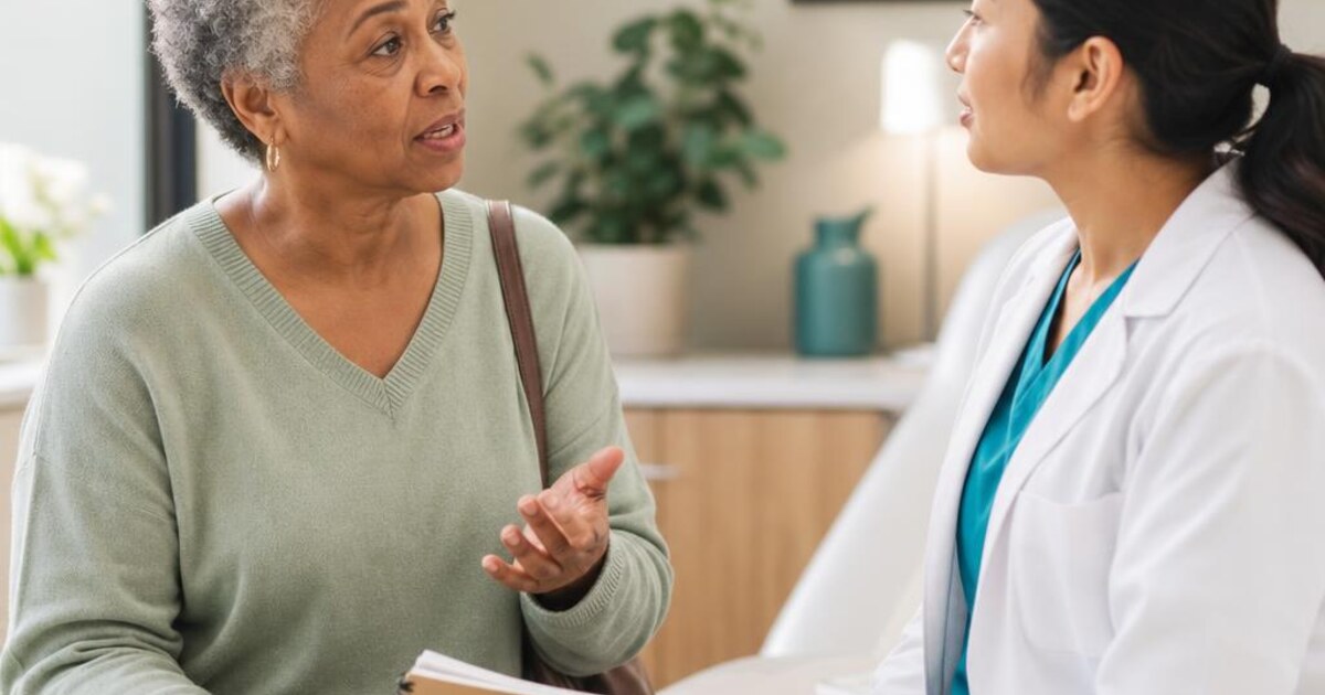 A mature patient discussing questions with a clinician during a doctor visit